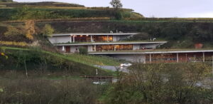 Modernes Haus in Hügellandschaft bei Dämmerung.