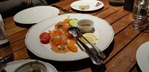 Lachs Carpaccio auf weißem Teller.