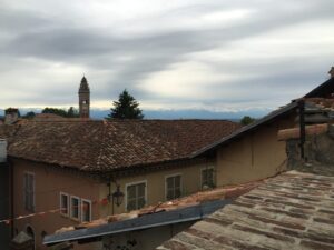 Italienische Stadtansicht mit Glockenturm und Bergen