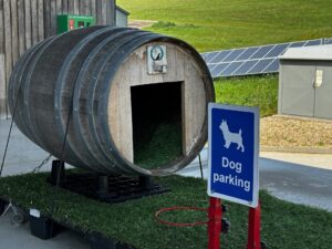 Fass als Hundeunterstand neben Schild "Dog parking".