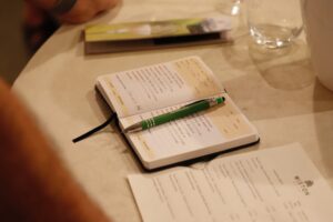 Notizbuch mit Stift auf Tisch bei Konferenz.